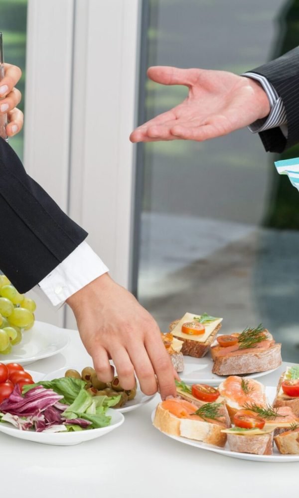 Colleagues at a corporate catering reception with canapés by a window in Palm Springs