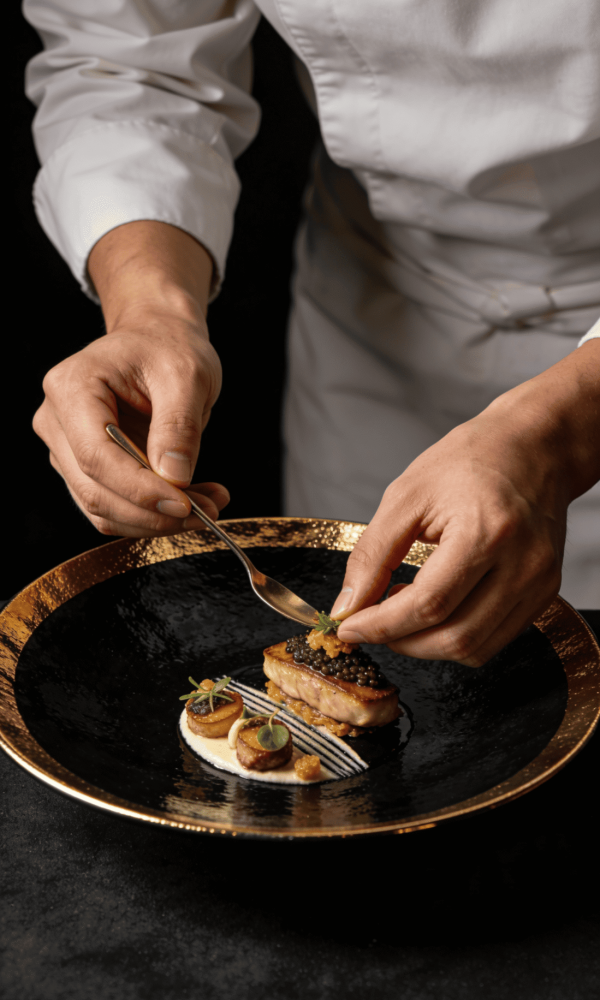 Elegant gourmet dish being plated by a chef